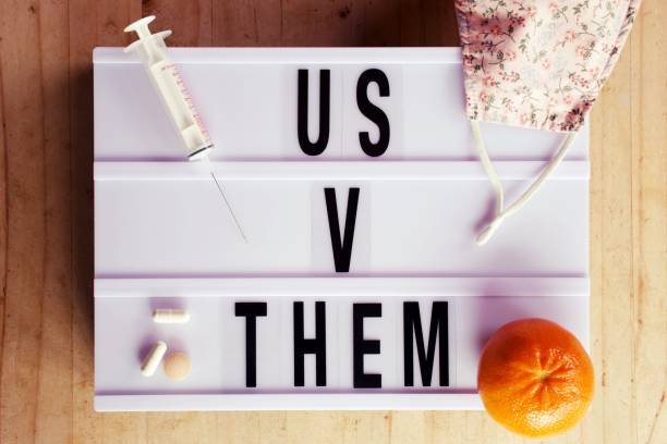 Us V Them in Lightbox Trend - Concept Vaccinated V Unvaccinated The words Us V Them in Lightbox Trend for Learning About Us & Them Politics or 'Othering'. What is the reason for Division? This is a Concept image for the Vaccinated V Unvaccinated Division. ideology stock pictures, royalty-free photos & images