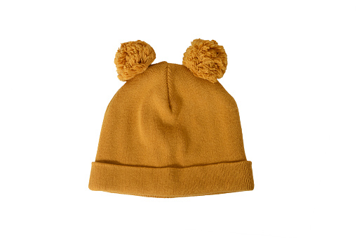 Yellow knit winter baby hat with pom poms isolated on white background. Mustard knitted beanie.