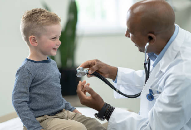 istock Doctor Showing a Boy How a Stethoscope Works 1353304900