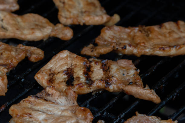 istock Food image of sliced pork grilling on a barbeque 1353315517