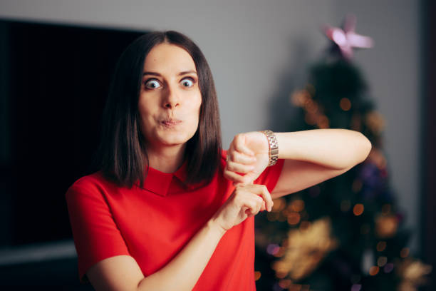 크리스마스 이브에 시계를 가리키는 파티 호스트 - 시간 확인 뉴스 사진 이미지