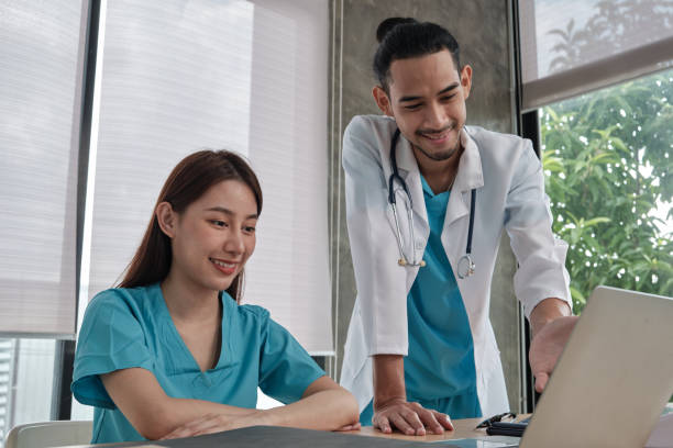 istock Two uniformed young doctors work in medical clinic office. 1353322804