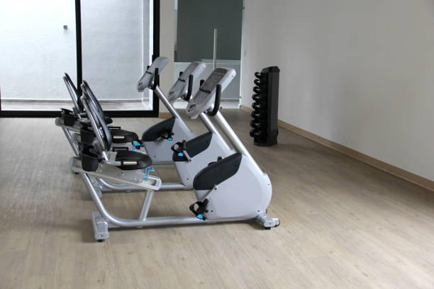 cyclette elettriche reclinabili in bianco e nero in una palestra per cardio, tonificazione gambe, bruciare calorie e perdere peso - spinning health club instructor gym foto e immagini stock