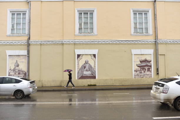 A man holding an umbrella and walking in the street