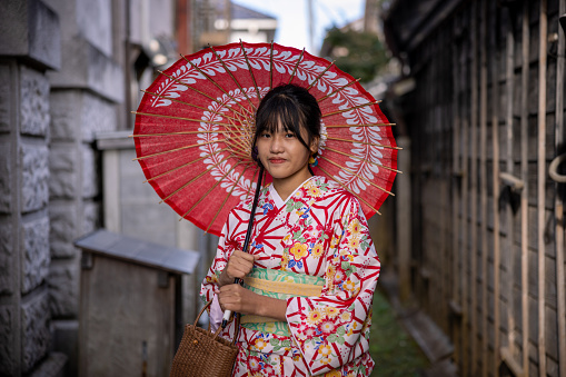 Teenage girl visiting traditional Japanese village Sawara, UNESCO World Heritage Site. Wearing Kimono and walking around the village.