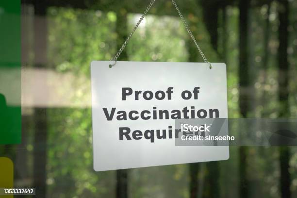 Signboard Proof Of Vaccination Required Hanging On The Door Front Of A Shop Stock Photo - Download Image Now