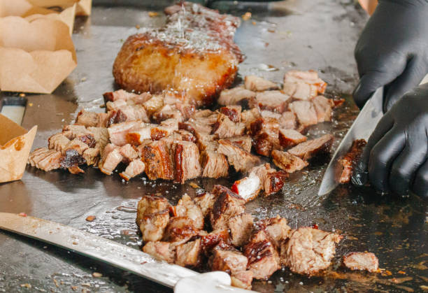 istock a hand cutting pieces of a meat 1353335372