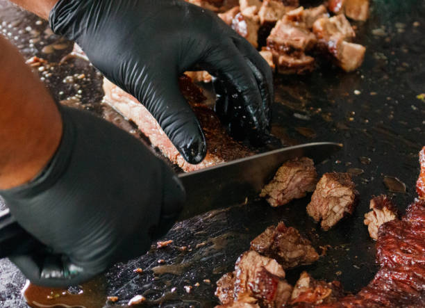 istock a hand cutting pieces of a meat 1353335381