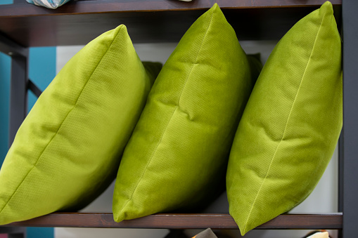 Green pillows on the shelf in the store.