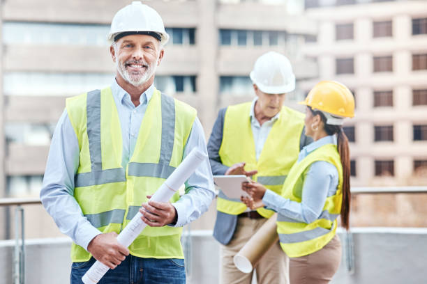 istock Portrait of a confident mature businessman holding blueprints while working at a construction site 1353341475