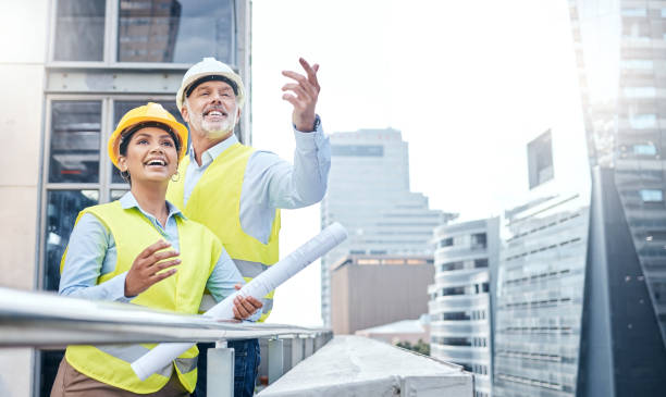 istock Shot of two businesspeople working together at a construction site 1353341489