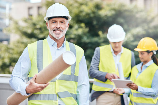 istock Portrait of a confident mature businessman holding blueprints while working at a construction site 1353341491