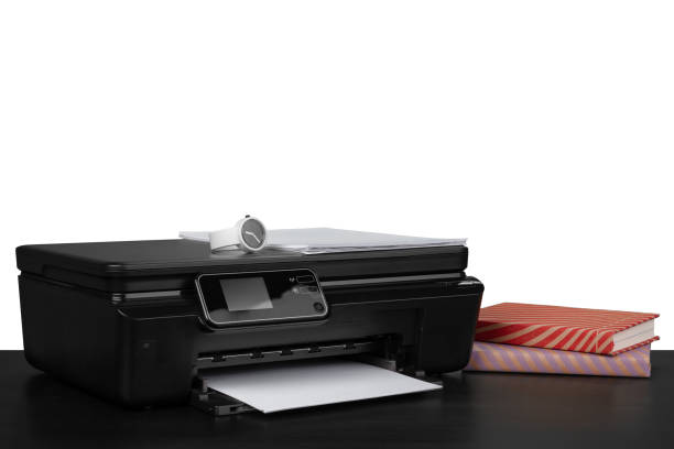 istock Printer and stack of books on black table against white background 1353347145