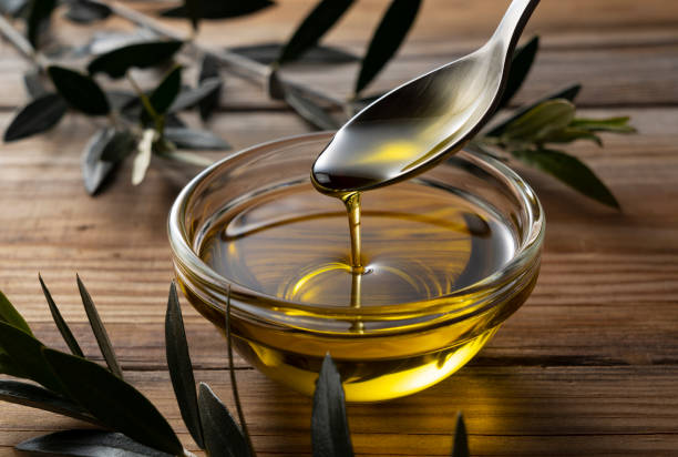 istock Spooning olive oil into a bowl placed on a wooden background 1353349271