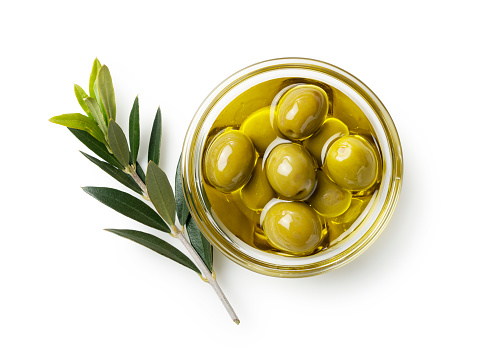 Frutos secos de oliva y aceite de oliva en un bol sobre fondo blanco. Vista desde arriba photo