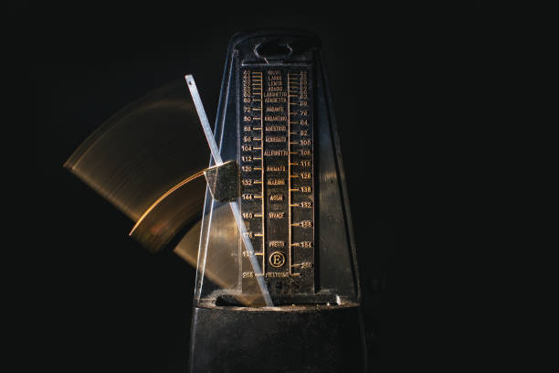 Metronome with moving rod on black background