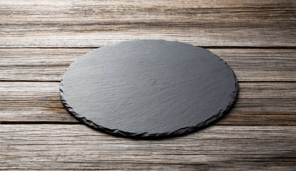 istock Stone plate placed on a wooden background, concept for composition 1353350549