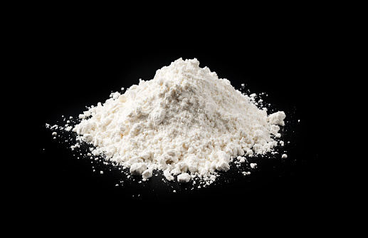 White flour on black background, dough ingredients