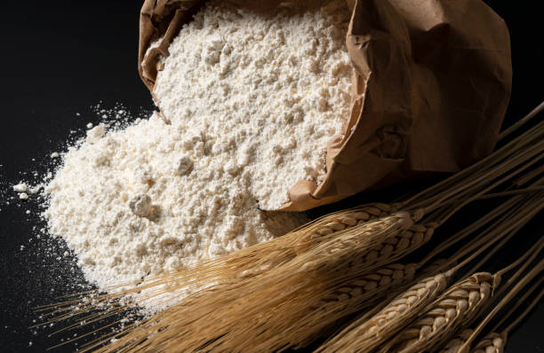 flour and ears of wheat on a black background. close-up, bread concept. - ground flour white heap imagens e fotografias de stock
