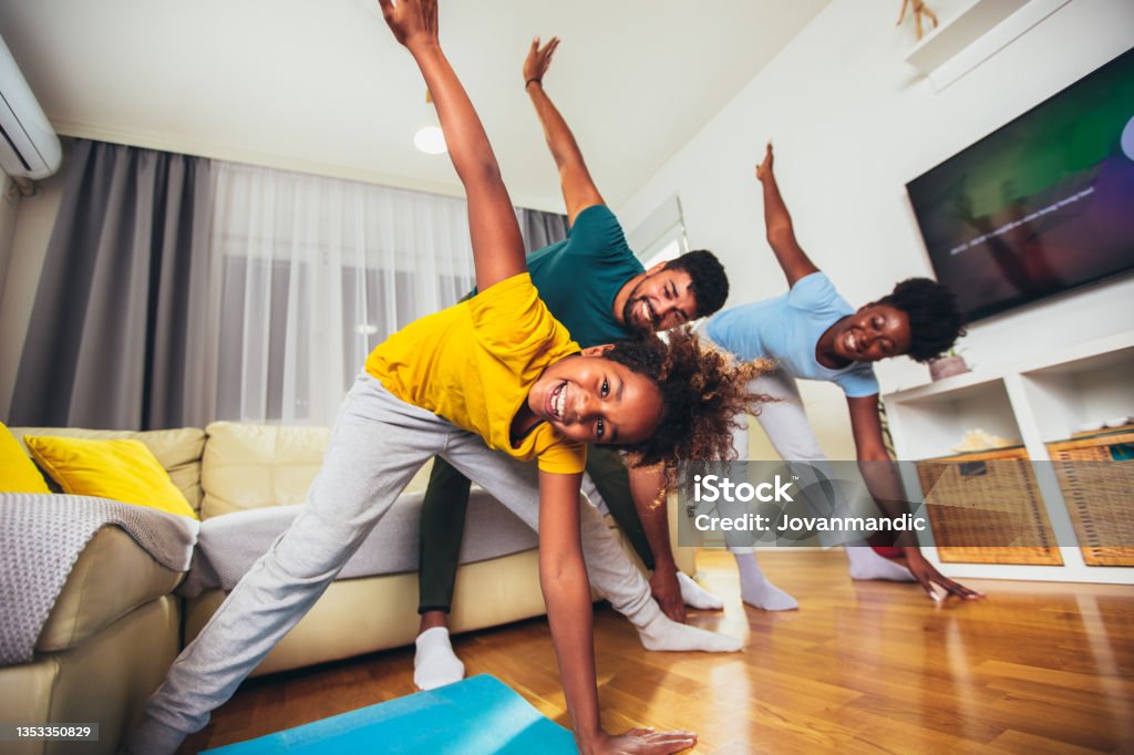 Healthy morning stretching - family doing gymnastic exercise at home Family Stock Photo
