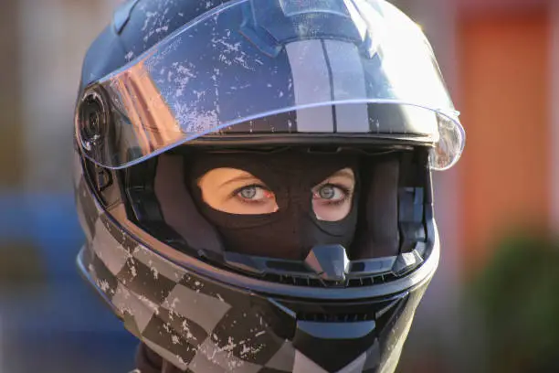Female race car driver wears helmet and balaclava (model released)
