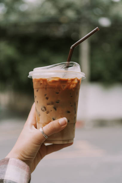 istock Female hand holding plastic cup with coffee 1353351961