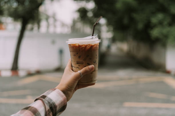 istock Female hand holding plastic cup with coffee 1353351976