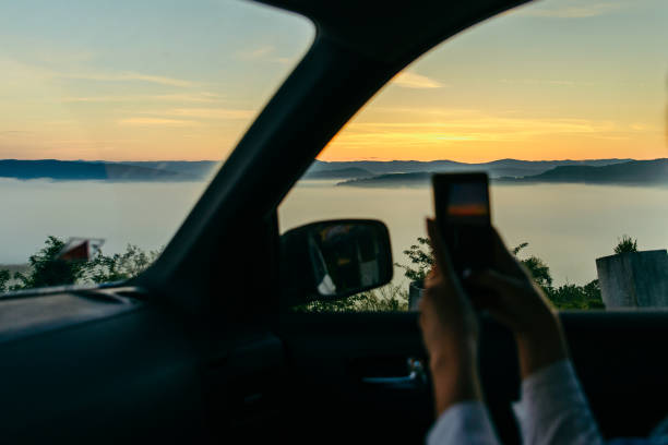 istock taking picture from the car on phone sunrise in mountains 1353352013