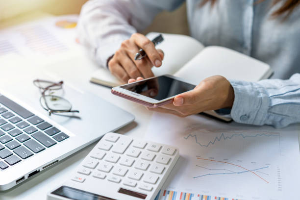 istock Businesswoman using mobile phone and working on Desk office with marketing graph statistics analysis 1353353340