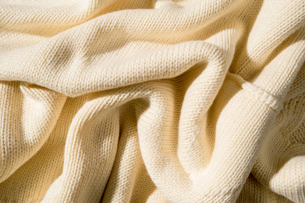 istock Knitted wrinkled texture in yellow color, top view, abstract background. 1353355748