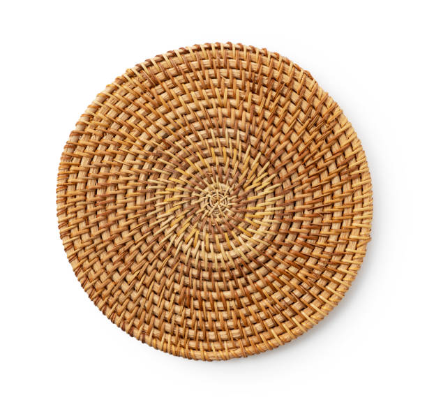 Handmade round woven placemat placed on a white background.