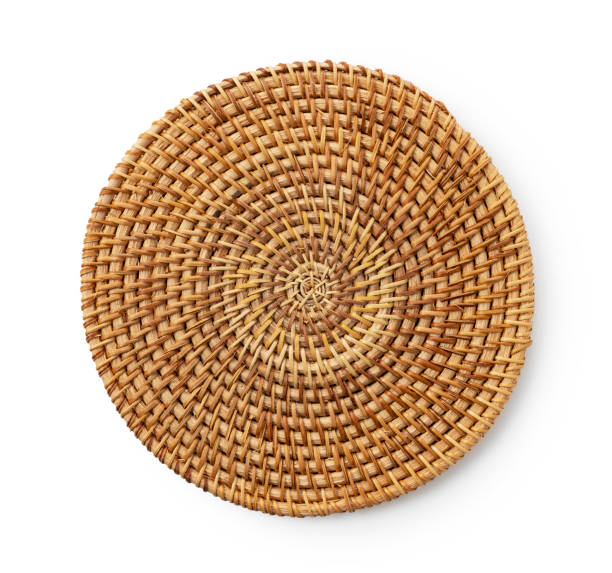 Handmade round woven placemat placed on a white background. Round woven placemat placed on a white background. View from above. straw stock pictures, royalty-free photos & images