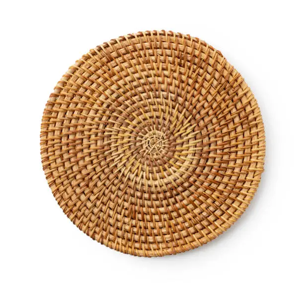 Round woven placemat placed on a white background. View from above.
