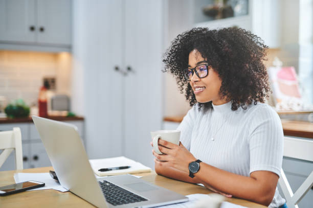 istock Shot of a young woman using a laptop and having coffee while working from 1353356081