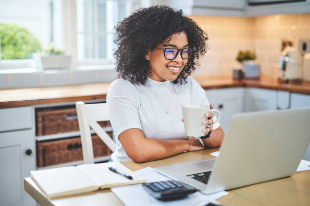 istock Shot of a young woman using a laptop and having coffee while working from 1353356085