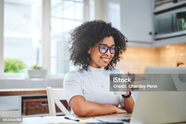 Shot Of A Young Woman Using A Laptop And Having Coffee While Working From Stock Photo - Download Image Now
