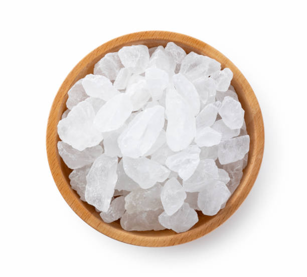 istock rock candy in a wooden bowl set against a white background. 1353357091