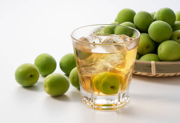 japanese plum wine and unripe plums on a white background. - plum fruit organic food and drink imagens e fotografias de stock