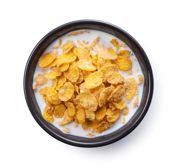 istock Milk and cornflakes in a black bowl. View from directly above. 1353357273