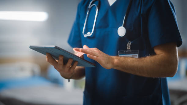 병원 병동: 인식할 수 없는 머리 간호사, 의사, 외과 의사는 디지털 태블릿 컴퓨터 건강 관리 활력 모니터링 컴퓨터 기계를 사용합니다. 고급 장비 와 전문 작업 현대 클리닉 - tablet pc 뉴스 사진 이미지