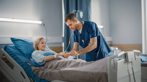 hospital ward: friendly head nurse connects finger heart rate monitor or pulse oximeter to beautiful female patient resting in bed. nurse does patient checkup after successful surgery. modern clinic - hospital patient bed nurse imagens e fotografias de stock