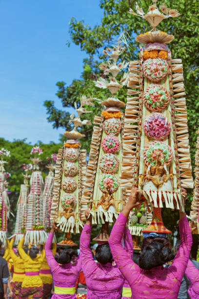Denpasar, Bali island, Indonesia - June 11, 2016: Group of beautiful women in traditional Balinese costumes carry on head religious offering for hindu ceremony on parade at art and culture festival.