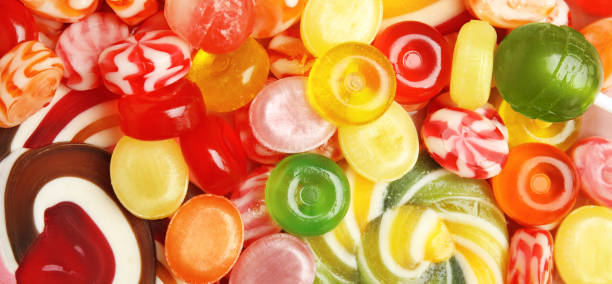 istock Different delicious colorful candies as background, top view. Banner design 1353358971