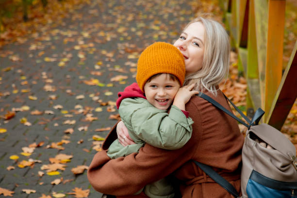 istock mom and son hugging in the autumn park 1353360686