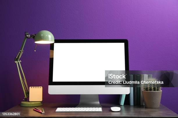 Comfortable Workplace With Modern Computer And Cactus On Table Near Purple Wall Space For Design Stock Photo - Download Image Now
