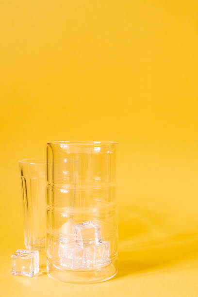 istock Empty glass with ice on a yellow background. Cocktail glass. 1353363859