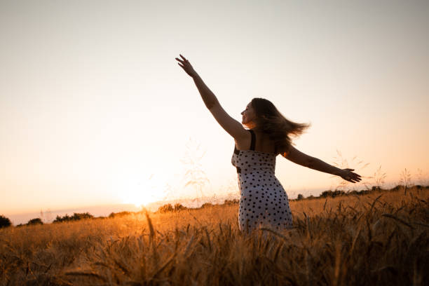 istock Woman Standing On Field Against Sky During Sunset 1353364618