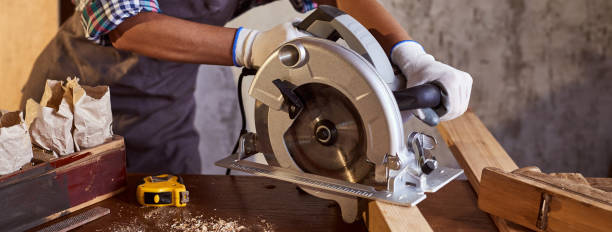 istock Skilled female carpenter using a circular saw. Woman worker in the carpenter workroom renovation. Small business concept 1353364867