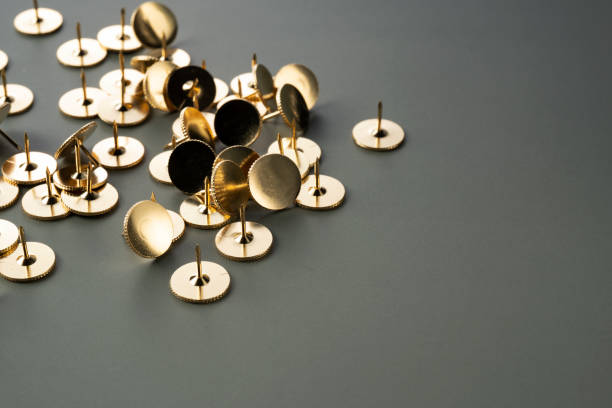 istock Gold thumbtacks placed on a green background 1353365413