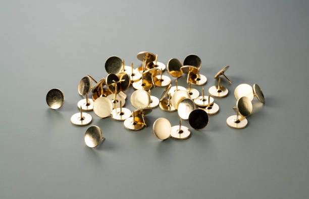 Gold thumbtacks placed on a green background